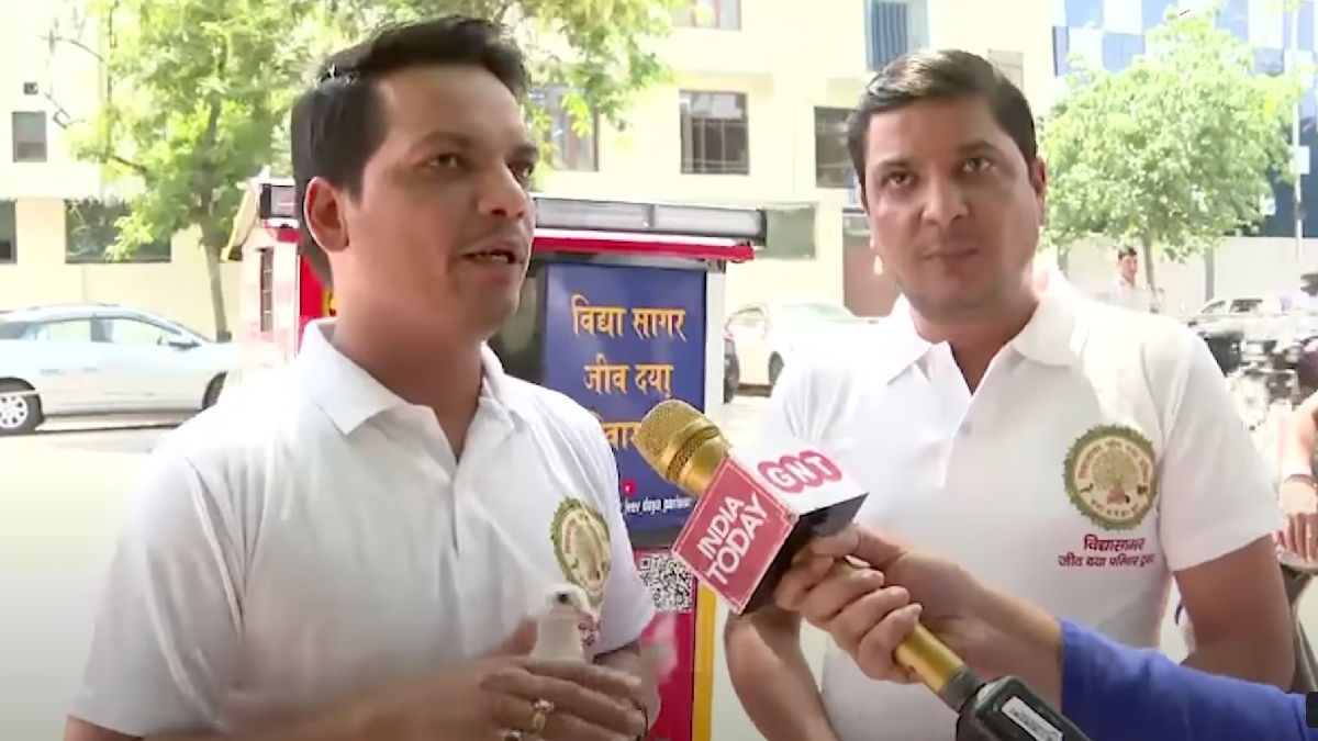 Jain brothers from Delhi, India, interviewing next to bird ambulance motorcycle for saving sick and injured birds